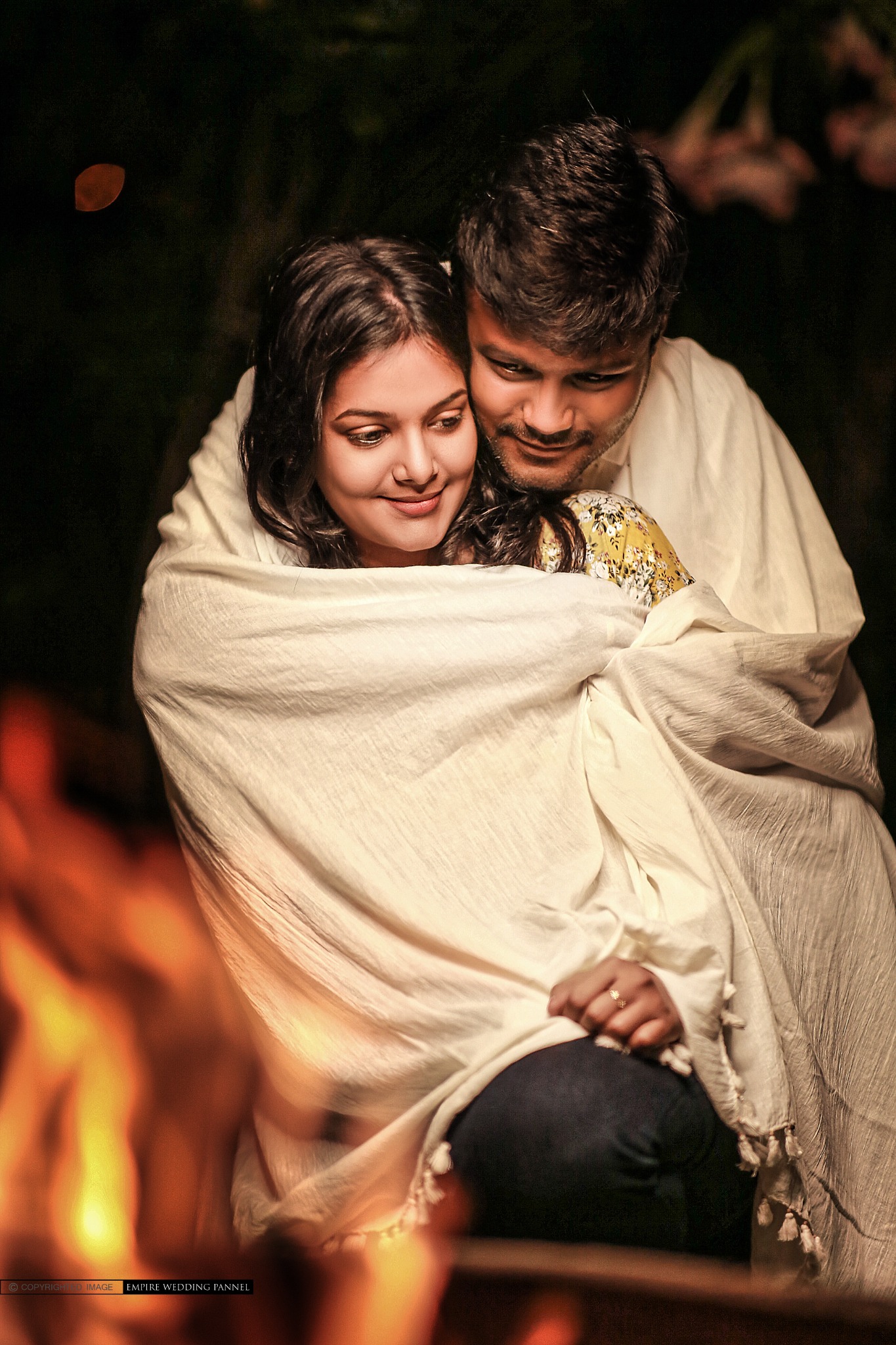 Couple portrait by a warm evening fire